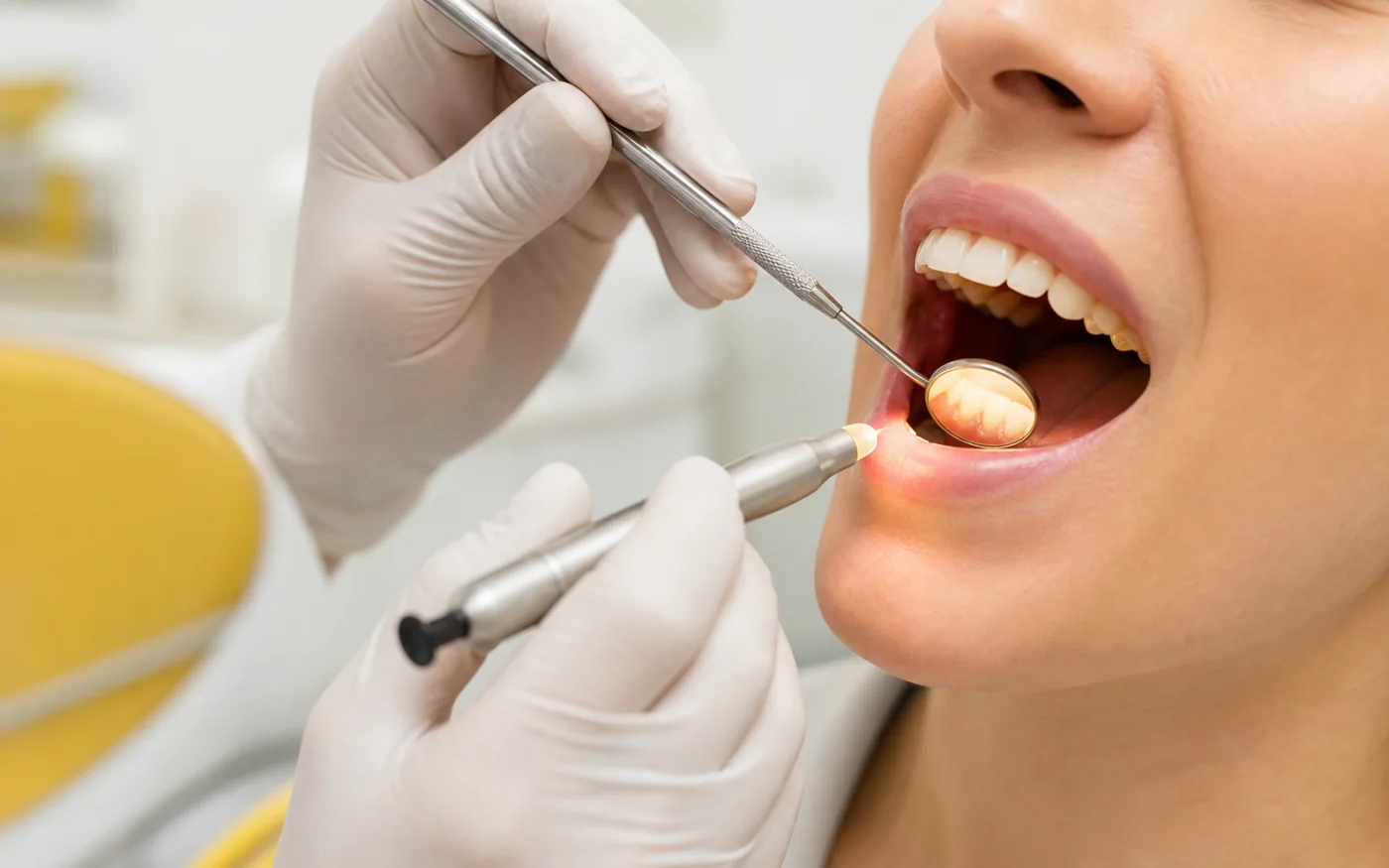 Dentist examining a patient's teeth with a dental mirror